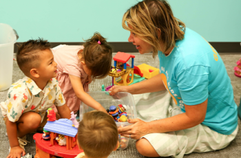 A volunteer sitting with toddlers