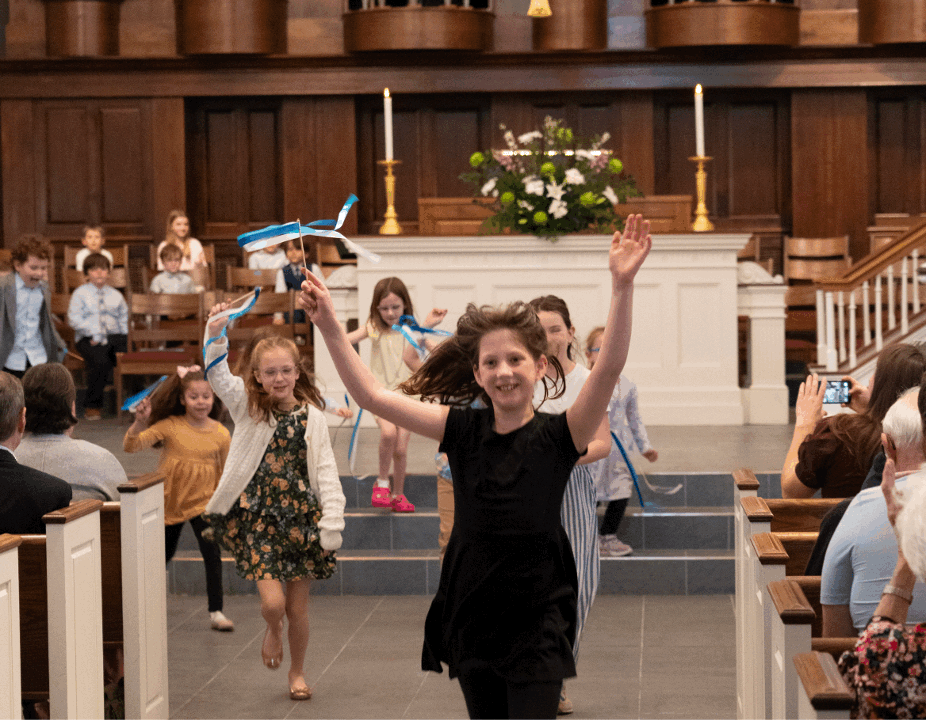 Children singing and ringing handbells