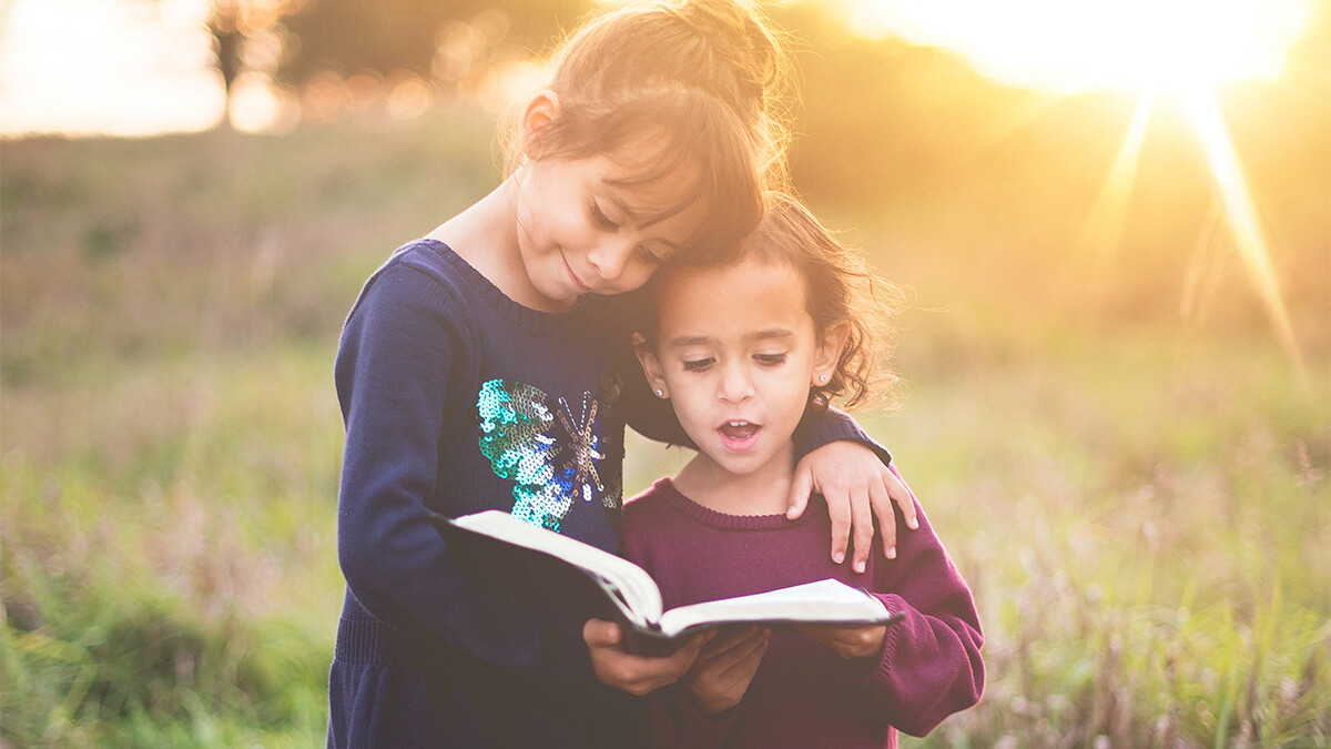 photo: two girls reading a Bible