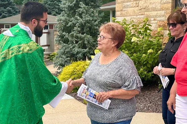 Fr. Phillip Rogier greets parishioners following Mass at Sts. Peter & Paul, Haubstadt, IN