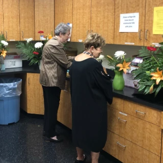 women volunteering to assemble flowers