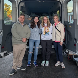 Group standing in front of a van