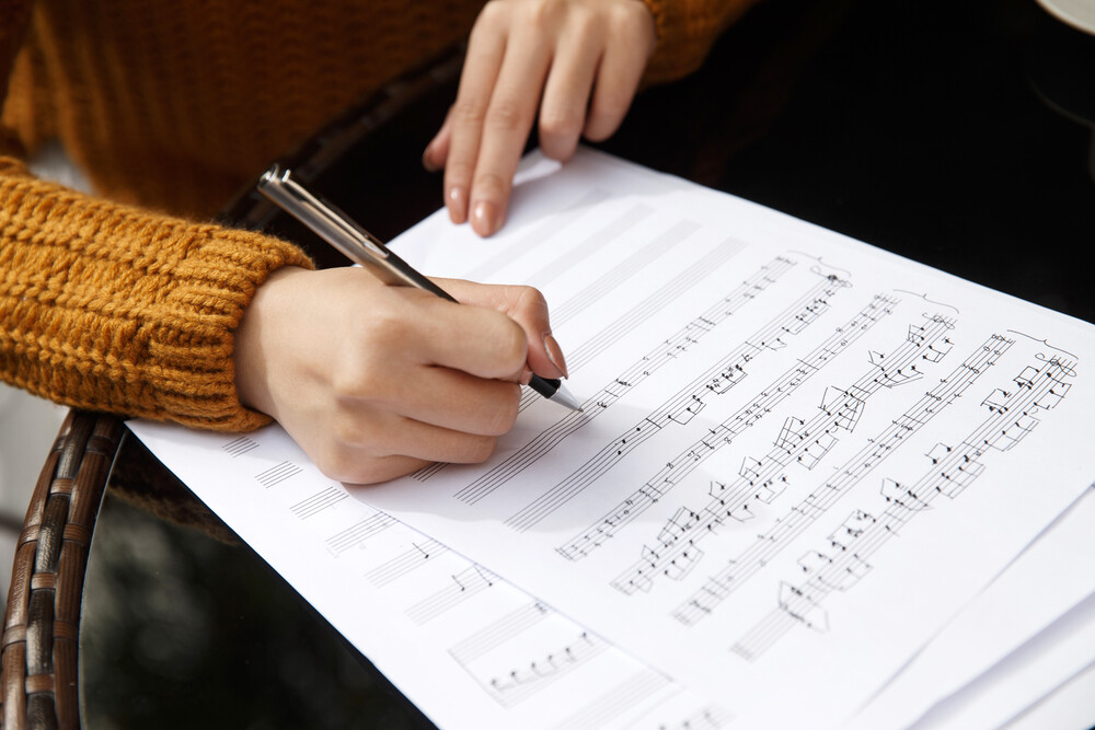 young-womans-hand-writing-music