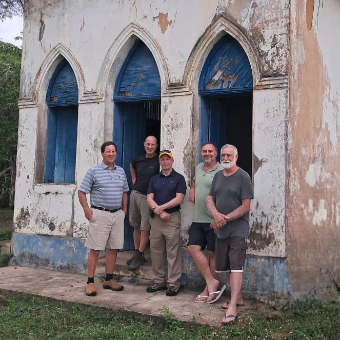 Construction Mission trip participants standing in front of the church they rebuilt.