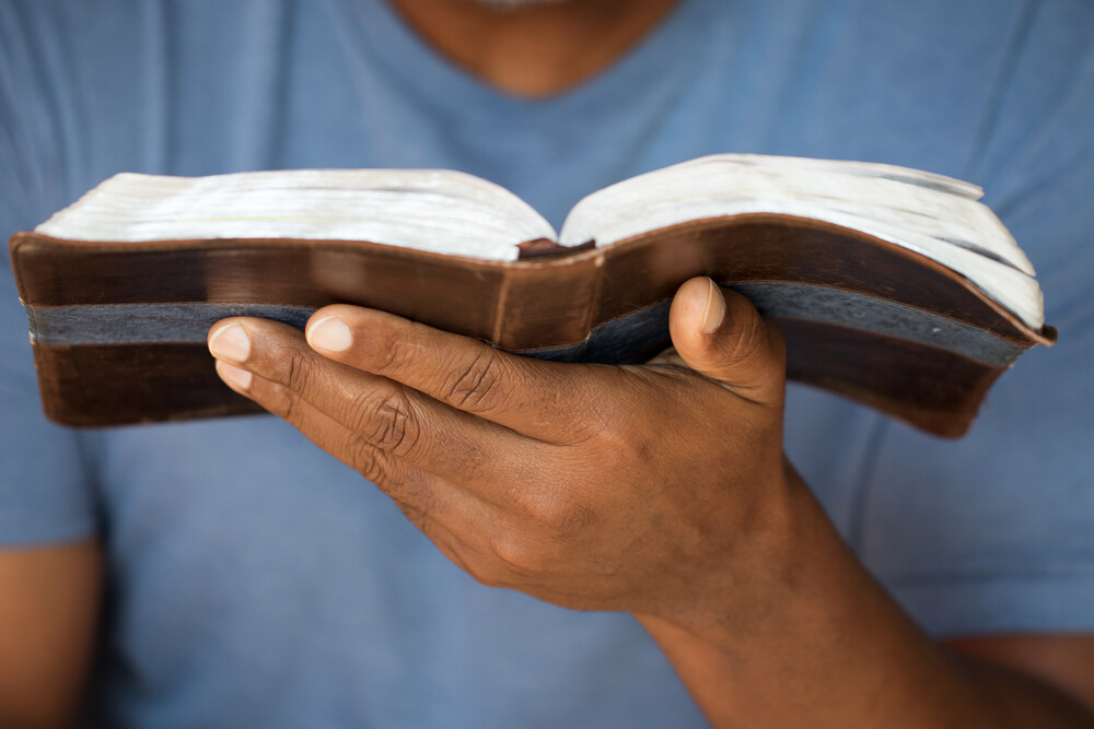 close-up-man's-hands-holding-open-Bible