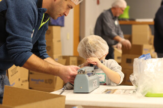 A father and son packing meals for Feed My Starving Children