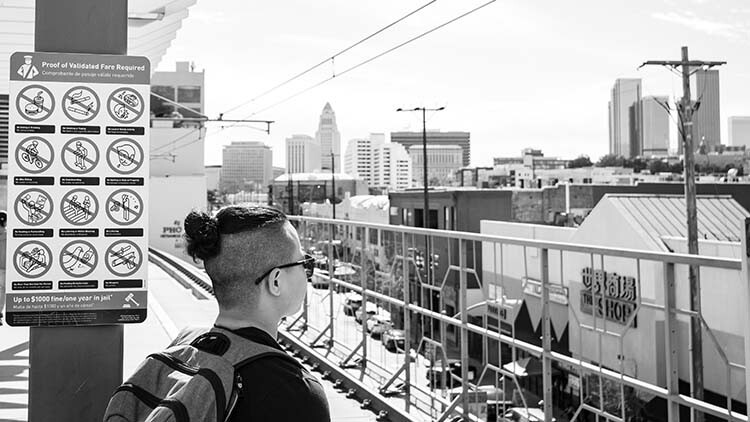 Male student waiting at train stop