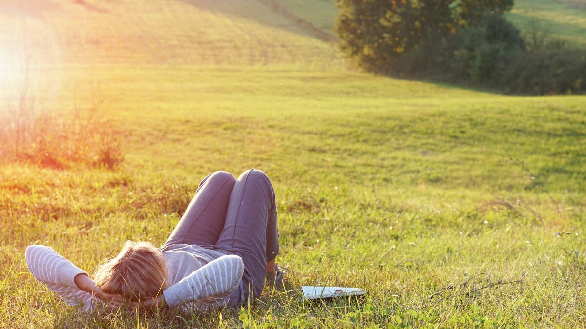 woman-resting-in-the-grass-of-an-open-field