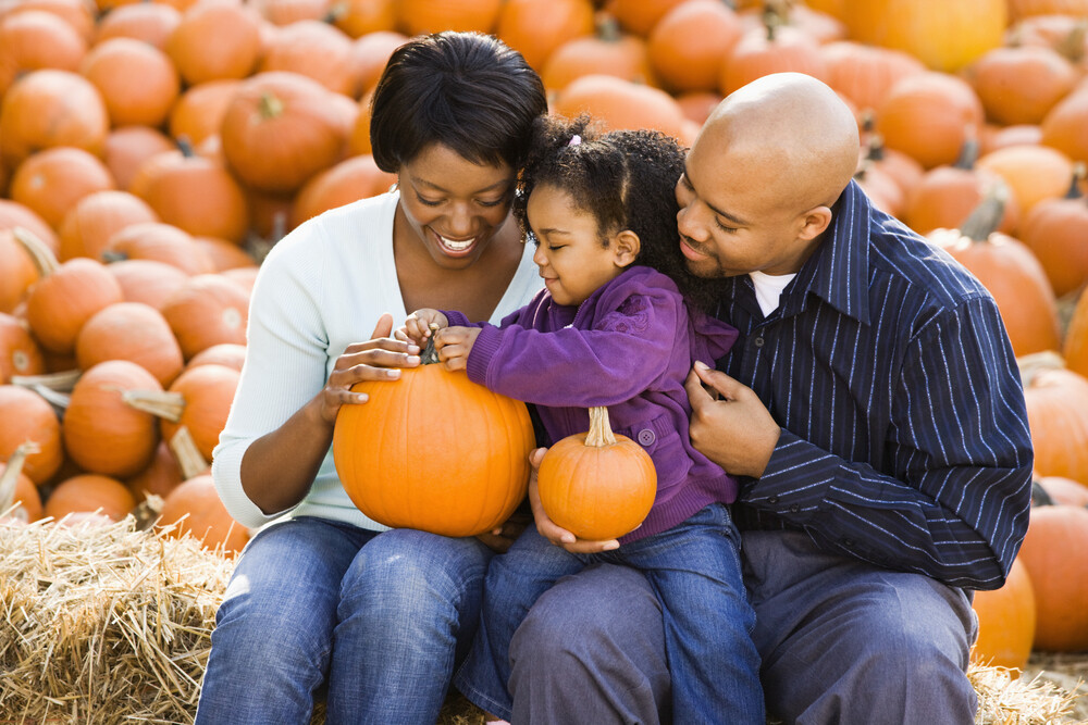 young-family-of-three-enjoying-fall-pumpkins