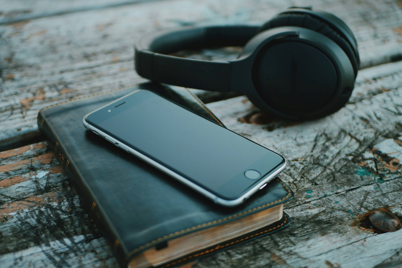 table with Bible, smartphone, and headphones