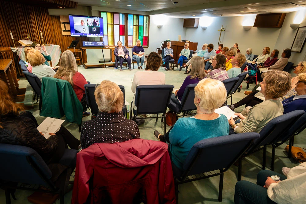 Women discuss faith in a circle during Women Offering Worship.