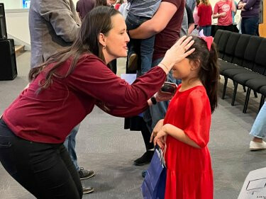 Child receiving a blessing in worship