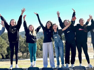 Youth raising standing with arms outstretched to the sky