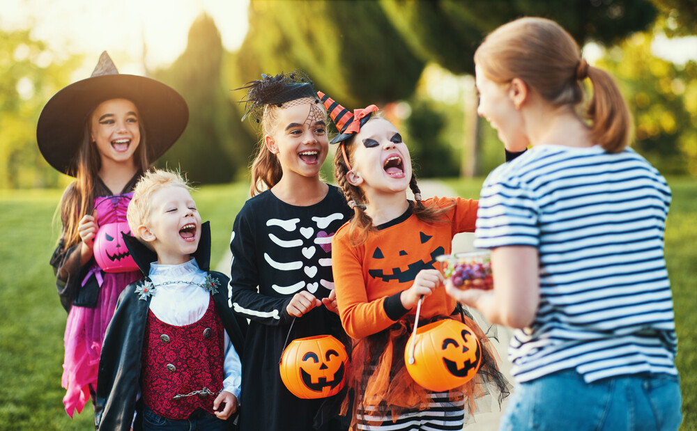 woman-passing-out-candy-and-engaging-kids-on-halloween