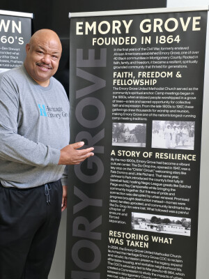 Rev. Tim Warner stands with sign detailing church history