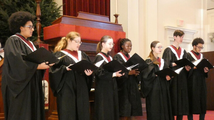 Youth choir in robes singing in sanctuary
