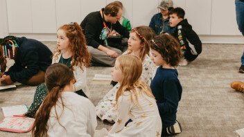 A volunteer sitting with toddlers