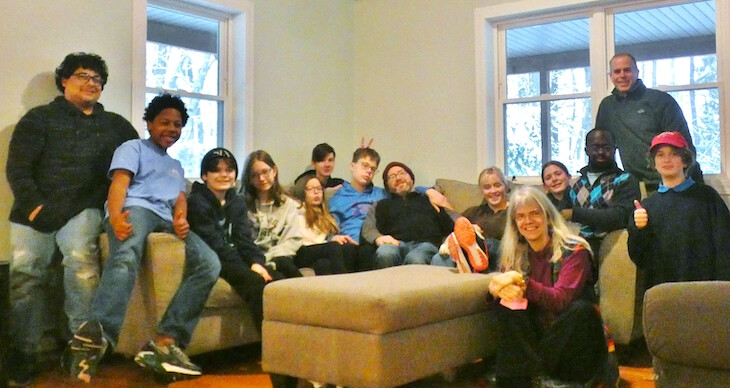 Middle and high school youth sit smiling on a couch