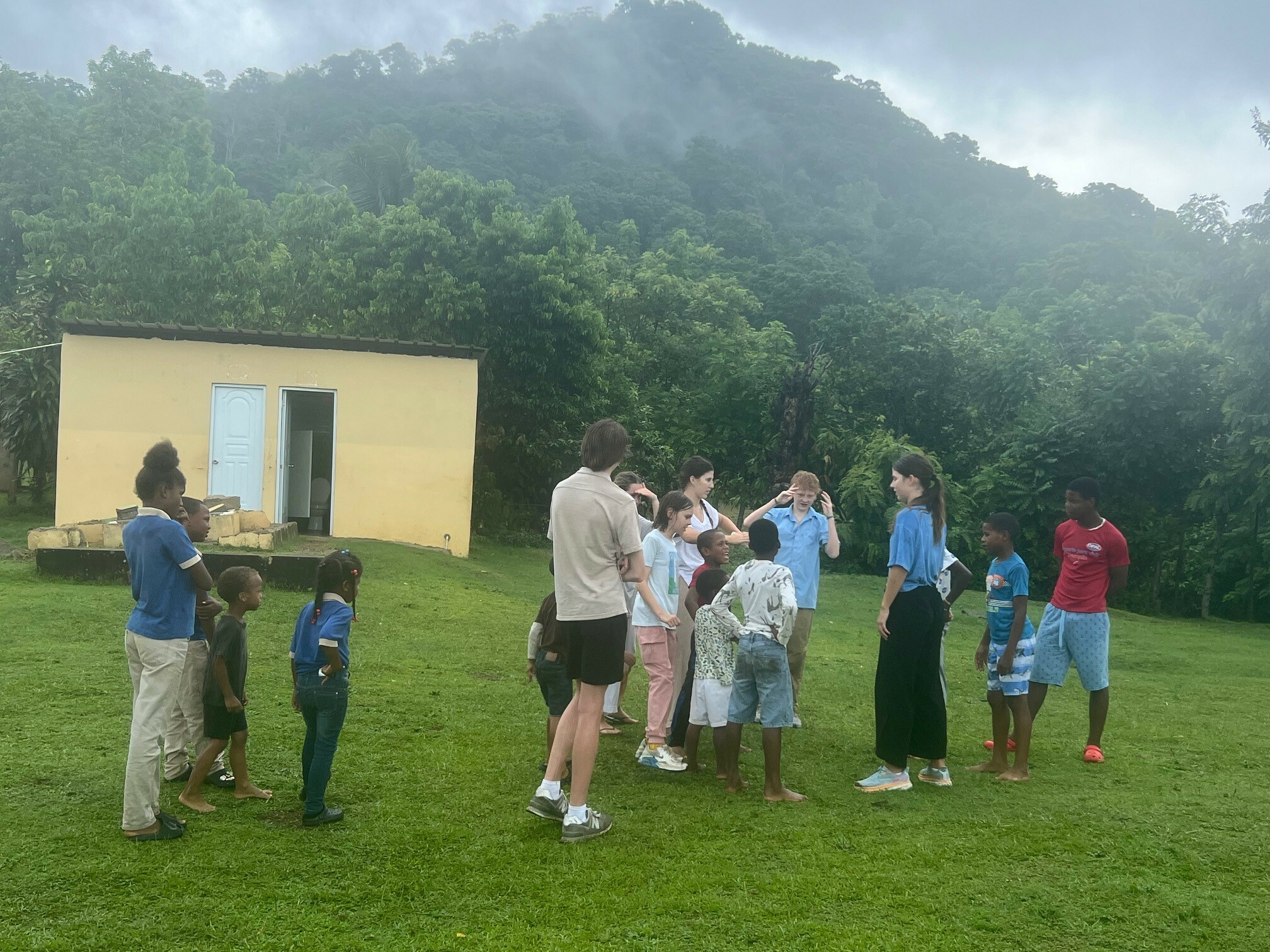 dominican and american children in a field doing motions to a song