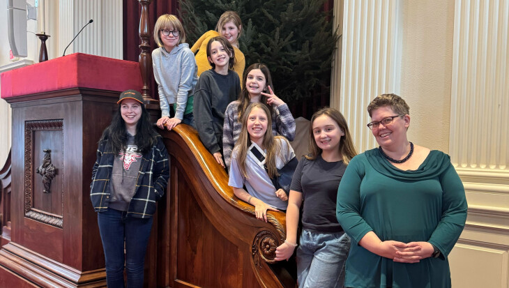 Children's choir on sanctuary staircase with accompanist and music director