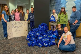 Youth display Blessing Bags packed for people experiencing homelessness.