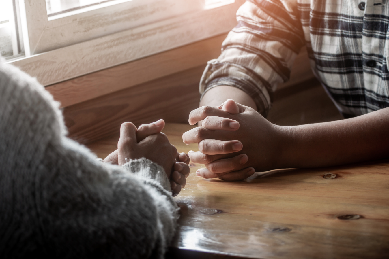 two people praying at a table