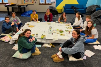 Youth seated around a seder table to learn about the Jewish tradition.