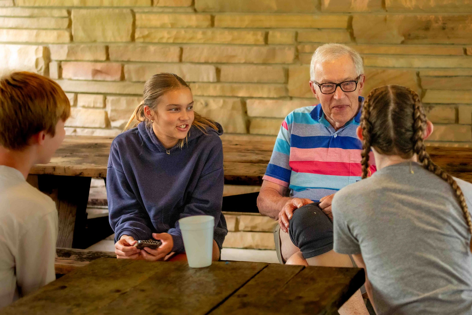 Teenagers talk with an older male counselor during a youth mission trip