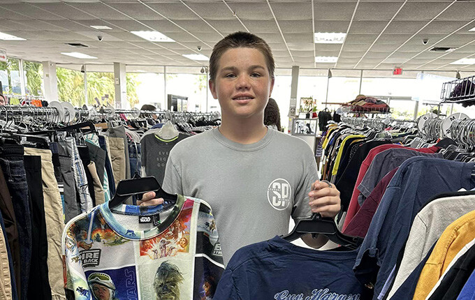 student holding up clothes to be sorted