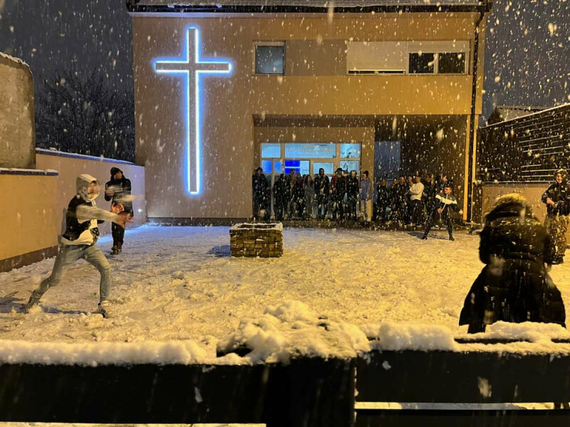 Snowball fight in front of the church building