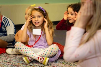 A girl holds are hands near her face during Sunday School.