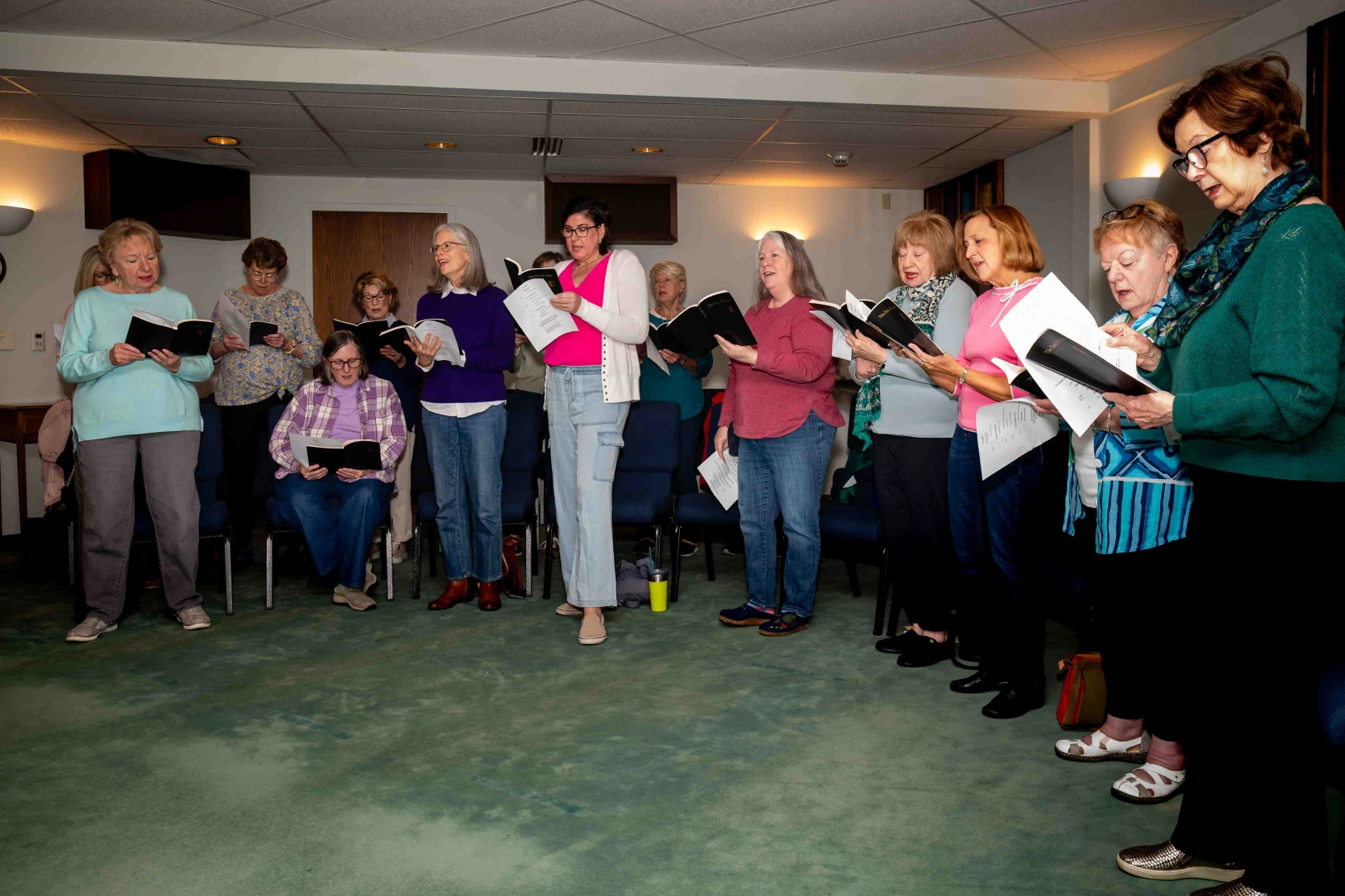 Women standing together and singing a hymn during Thursday worship.