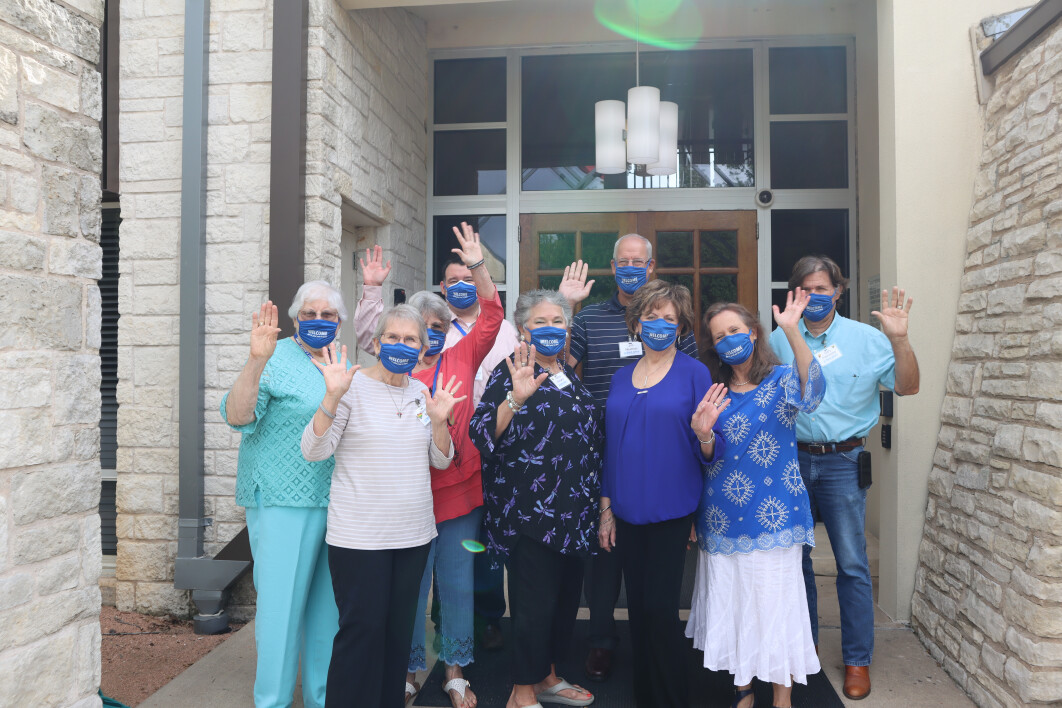 A photo of Saint John's hospitality team, masked and waving