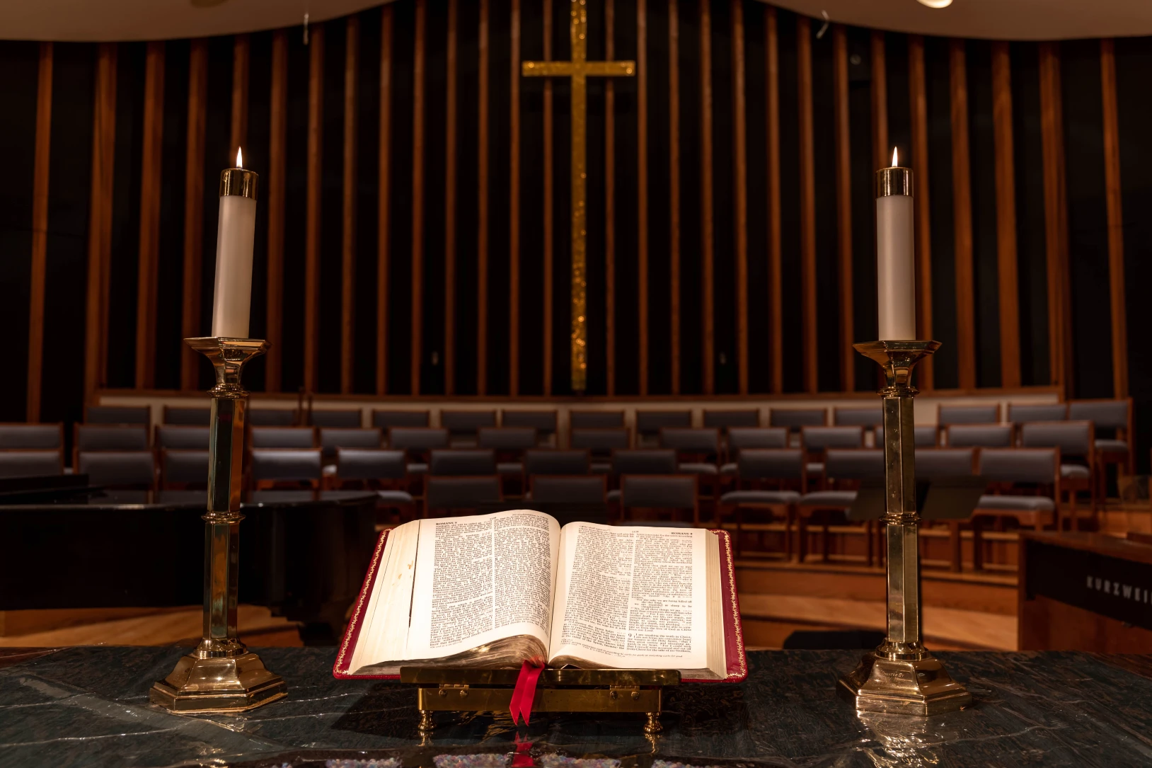 An open bible flanked by two candles on the altar at UMCWFB.