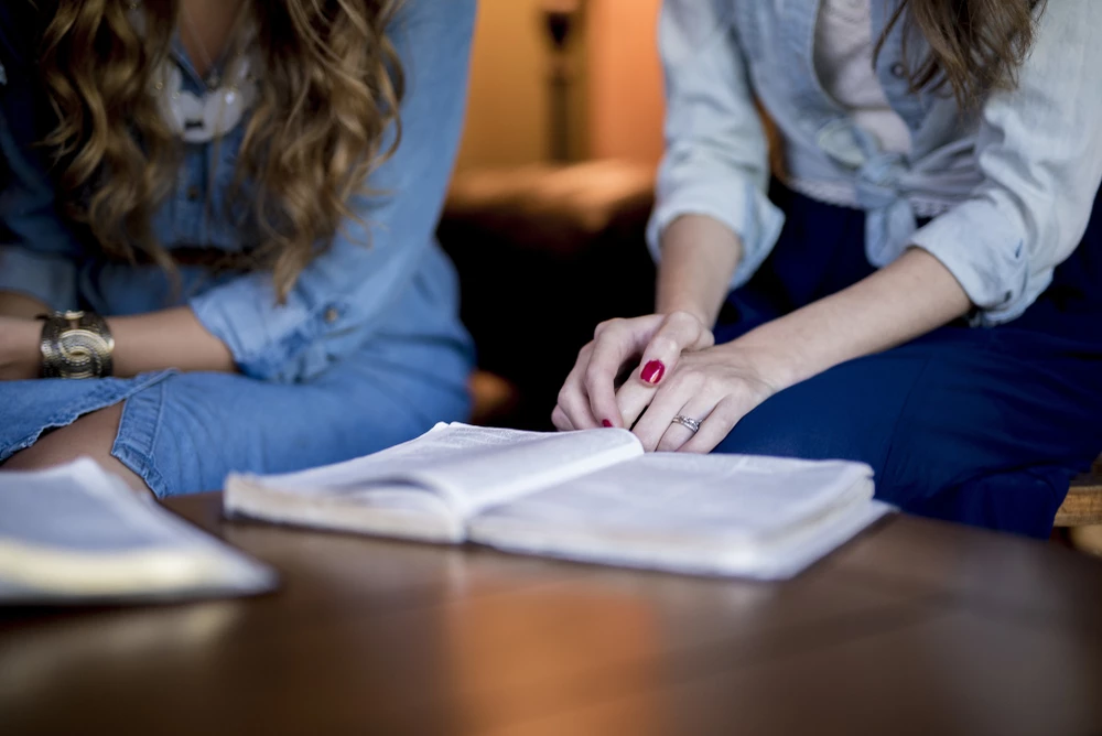 close-up-shot-of-two-women-reading-and-studying-the-Bible-together