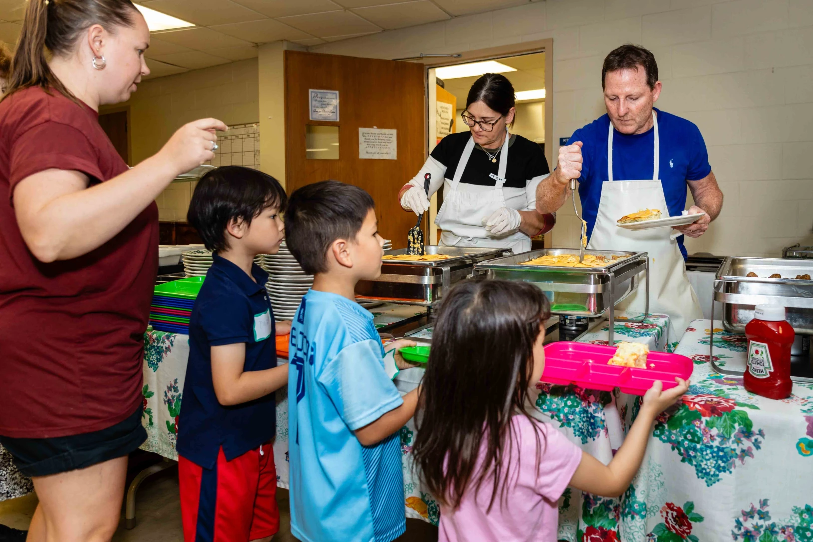 Children wait to be served food during the Wednesday Community meal.
