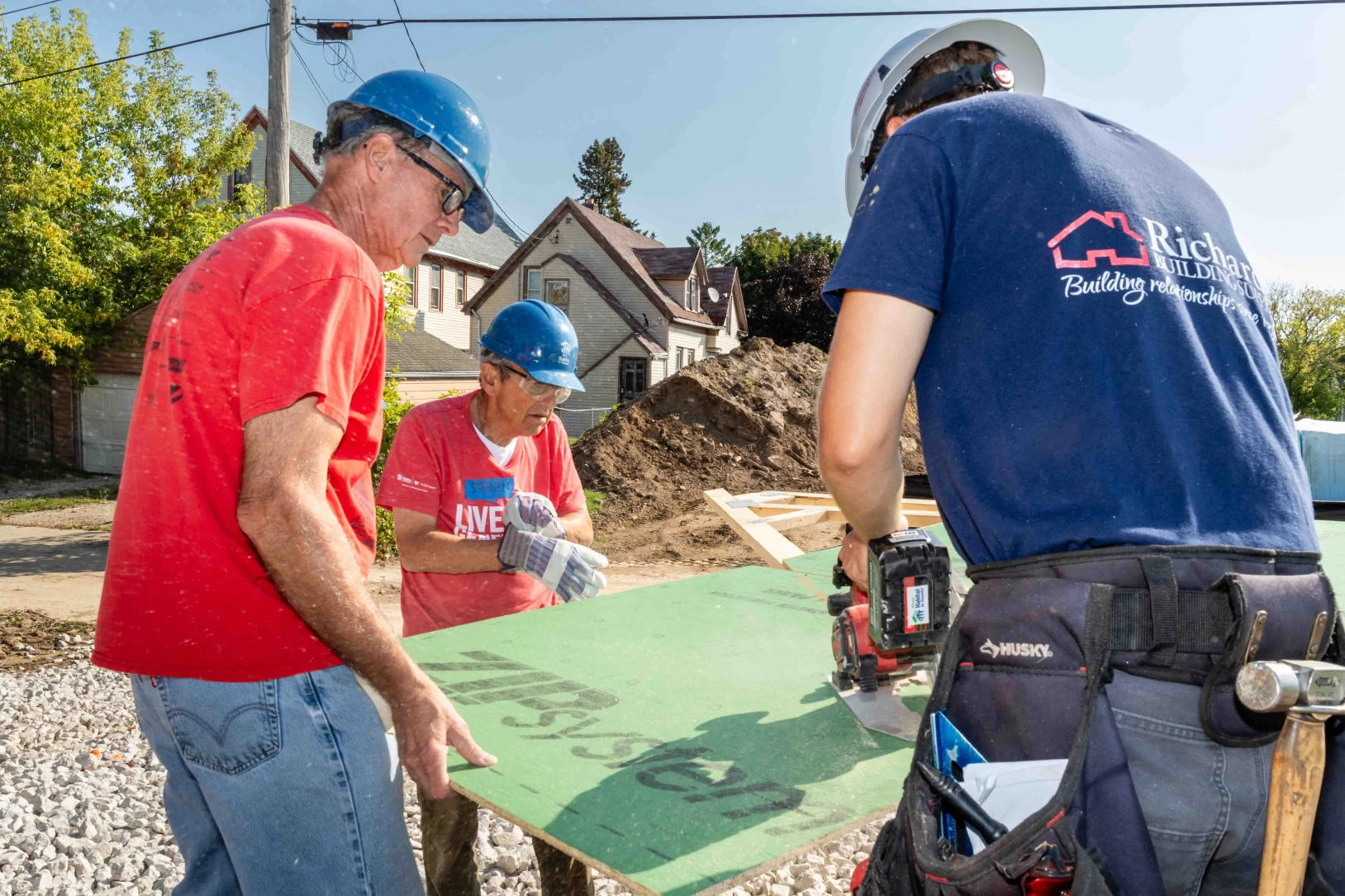 Men in hardhats help build a home in Milwaukee with Habitat for Humanity.