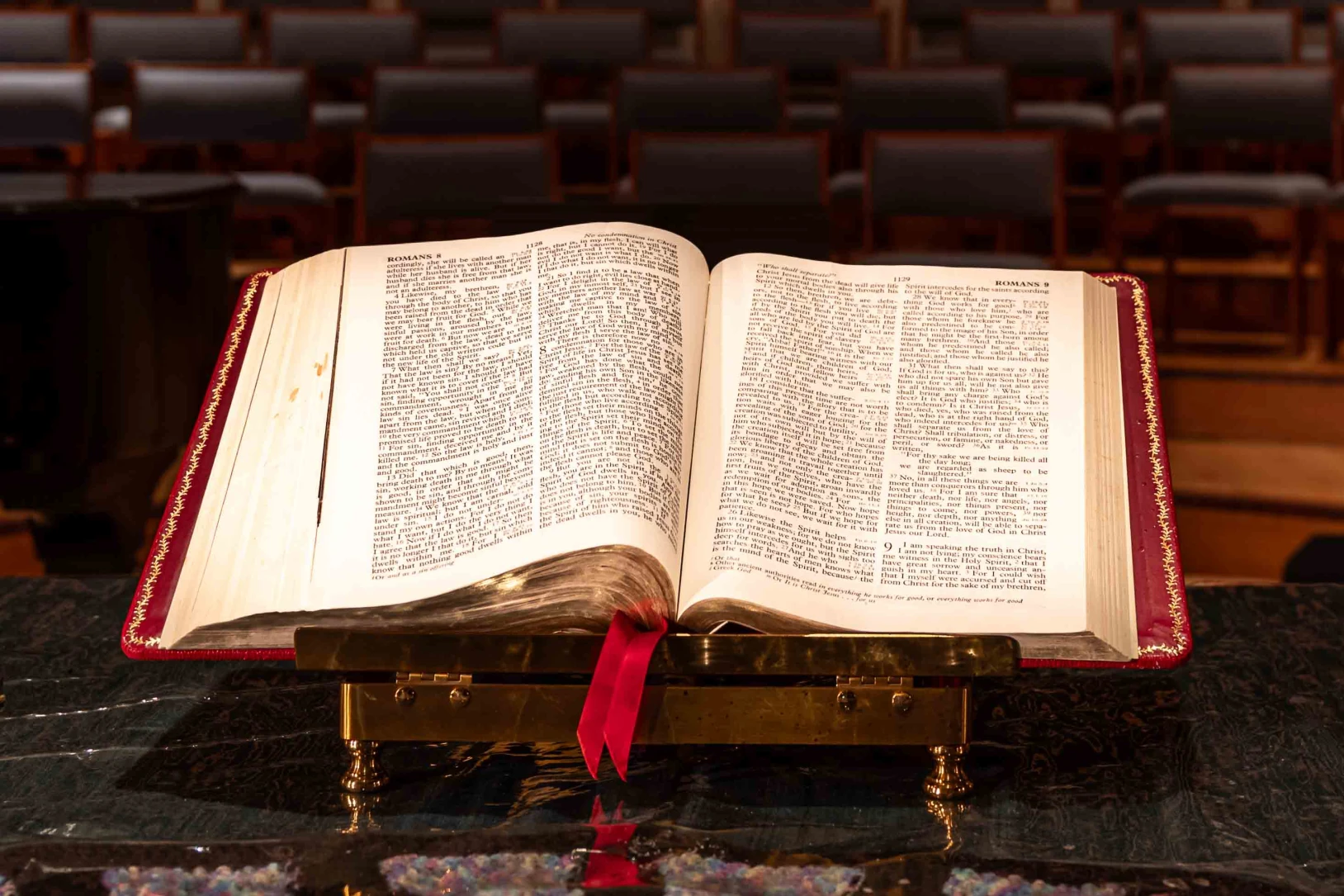 An open bible flanked by candles on the altar of the church