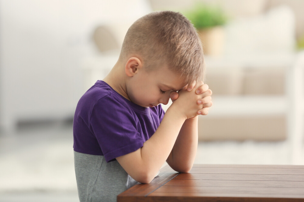 young-boy-praying-to-God-at-the-table