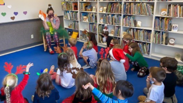 teacher reading aloud to children in a library