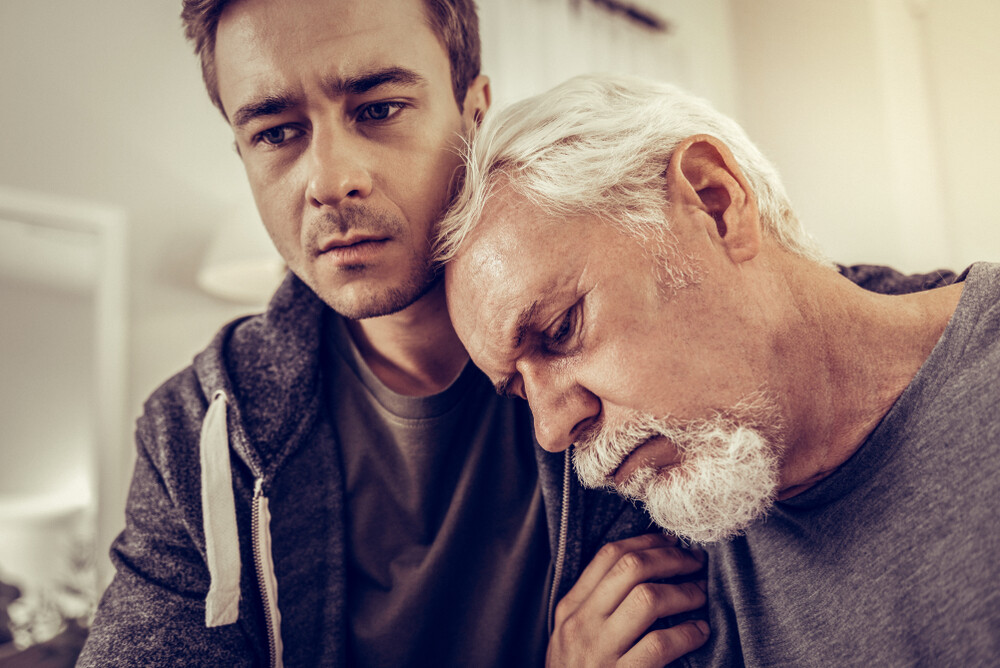 young-man-comforting-his-grieving-father