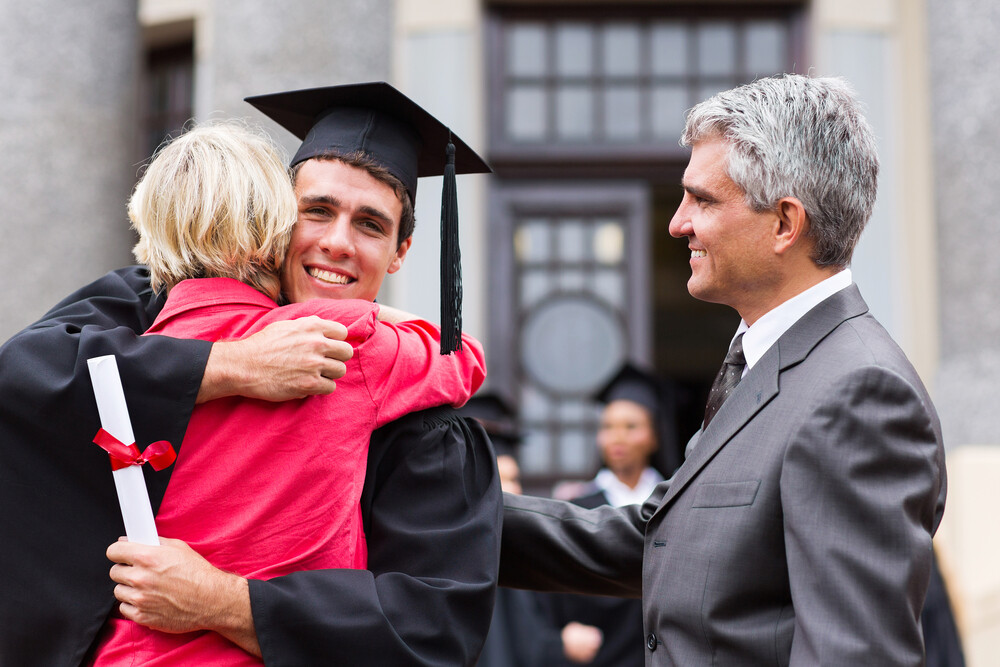 graduate-with-his-parents-hugging-his-mom