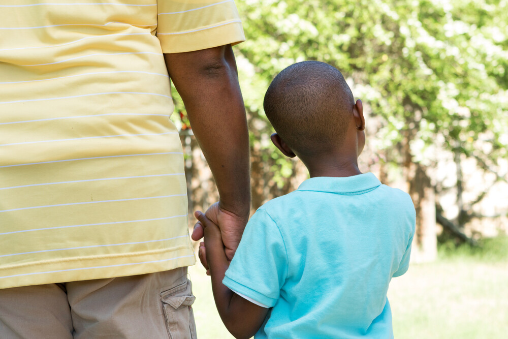 rear-view-of-father-and-young-son-holding-hands