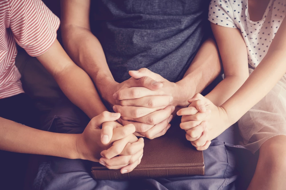 close-up-of-parent-praying-with-two-children