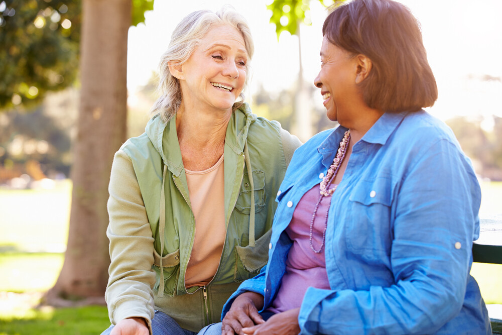 two-happy-senior-women-outdoors-talking