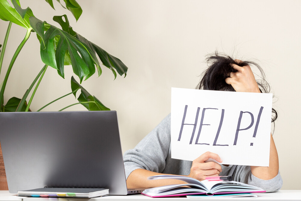 tired-frustrated-woman-hiding-behind-a-help-sign