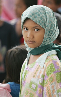 A young girl shares a tent with several other families at a camp for people displaced by the 2005 tsunami in Indonesia