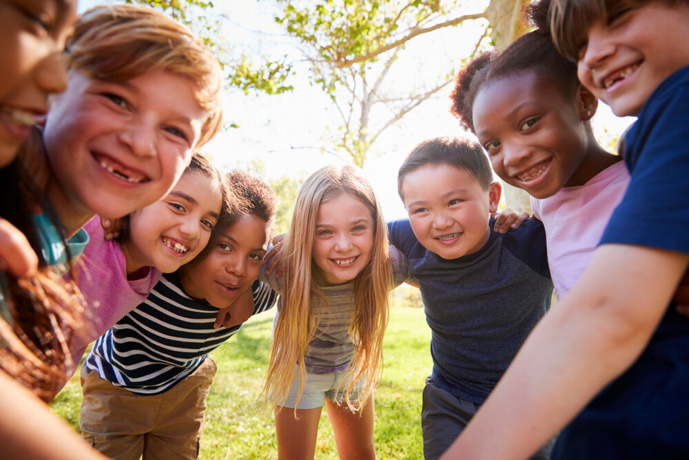 group-of-happy-children-lean-into-camera-embracing