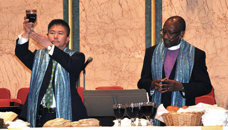The Rev. JW Park, left, superintendent of the Central Maryland District and Dean of the Cabinet, and Bishop Marcus Matthews, episcopal leader of the Baltimore-Washington Conference, celebrate Communion during the Pre-Conference Session April 30 at First UMC in Hyattsville.