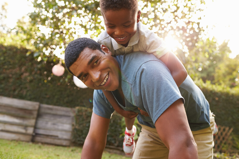 young-African-American-boy-climbing-on-his-dad's-back
